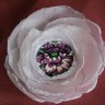 Flori mov, floare realizata din petale de voal alb creponat si avand in centru o pata superba de culoare, in ,,persoana” unei minunate flori mov:); diametrul: cca 9-10 cm; se prinde cu ac de brosa argintiu